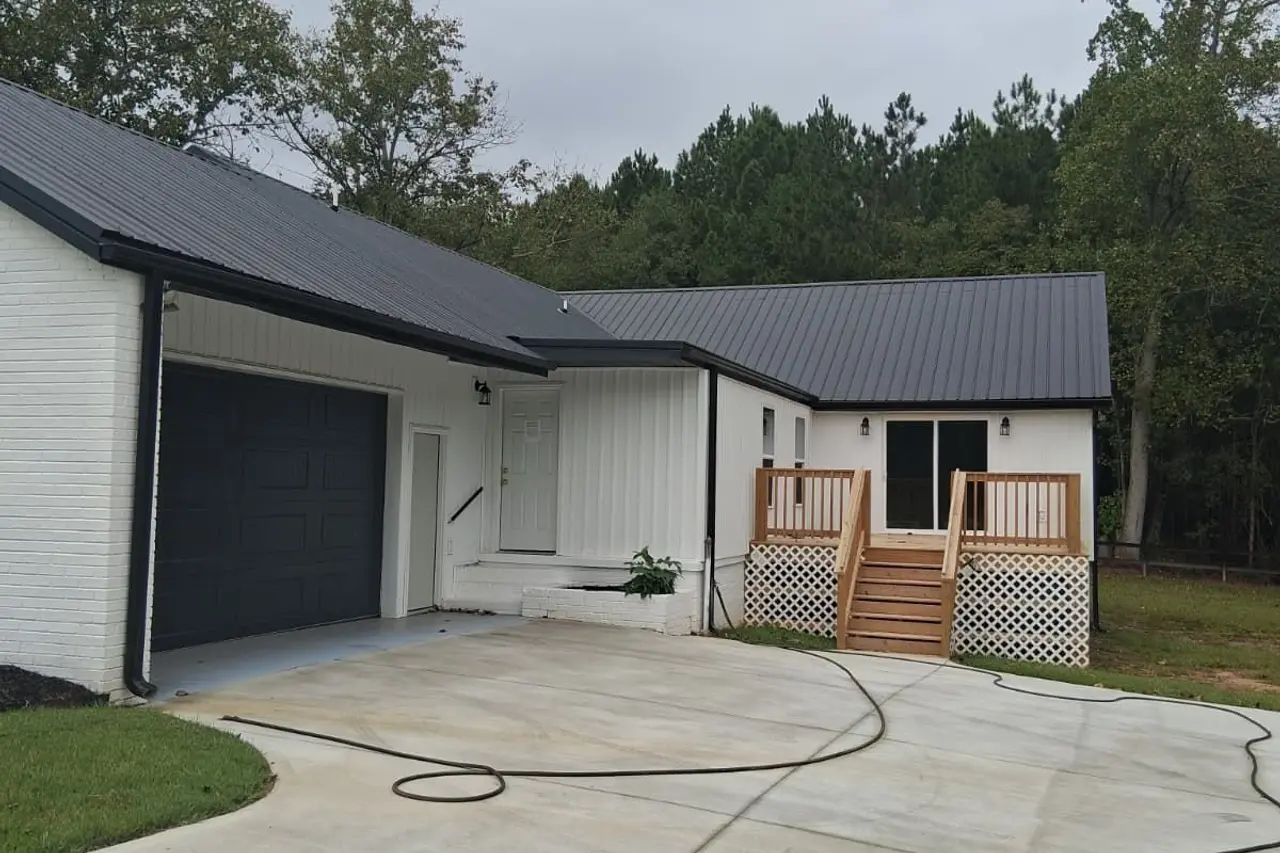 Single-story home with a metal roof, new siding and a concrete driveway