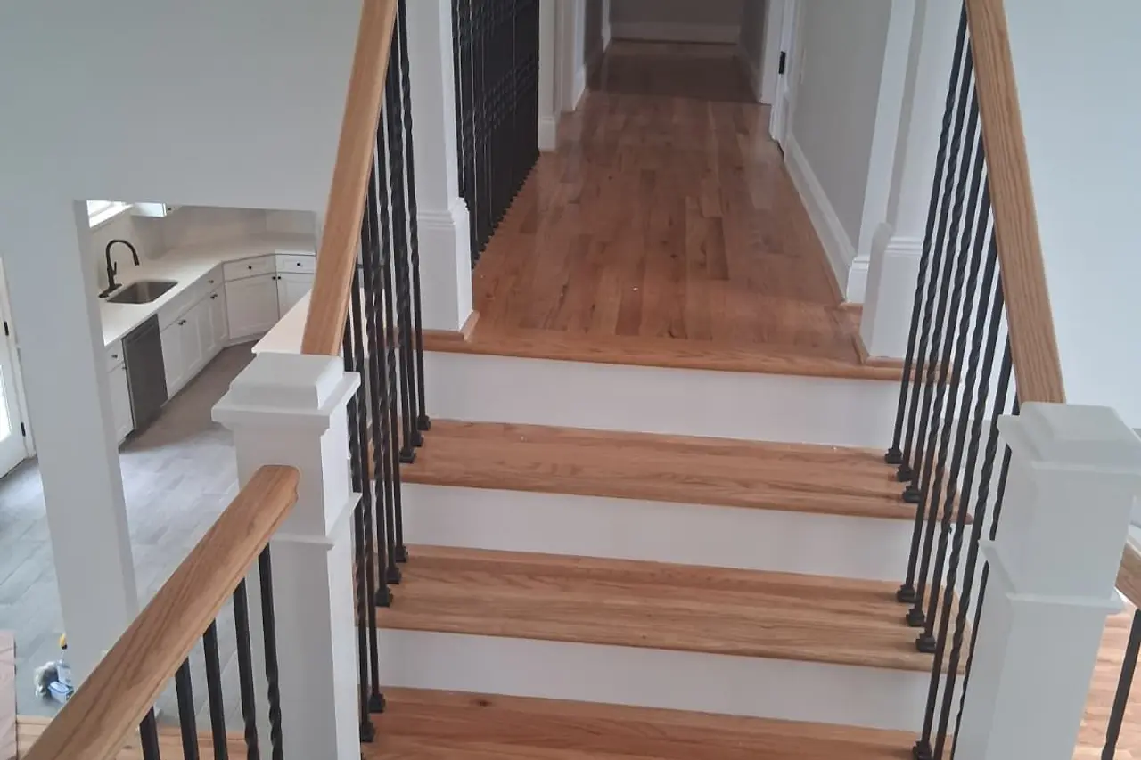 Staircase with wood treads, handrail and black balusters